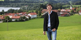 Gerhard Frey vor Sulzberg Gerhard Frey steht vor Sulzberg und trägt eine Trachtenjacke